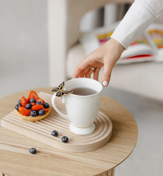 Puodelis su juodu drugeliu