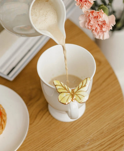 Puodelis su geltonu drugeliu