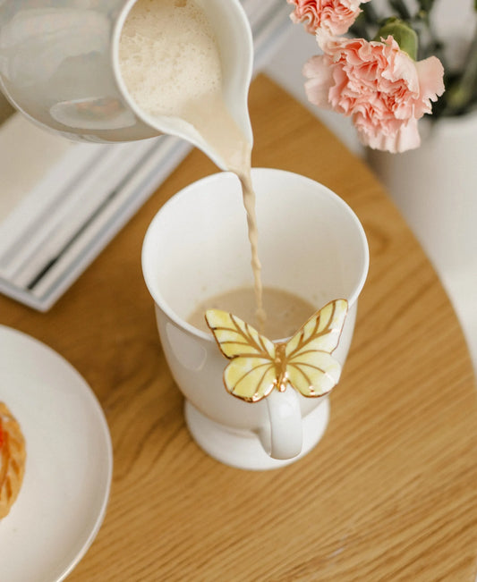 Puodelis su geltonu drugeliu